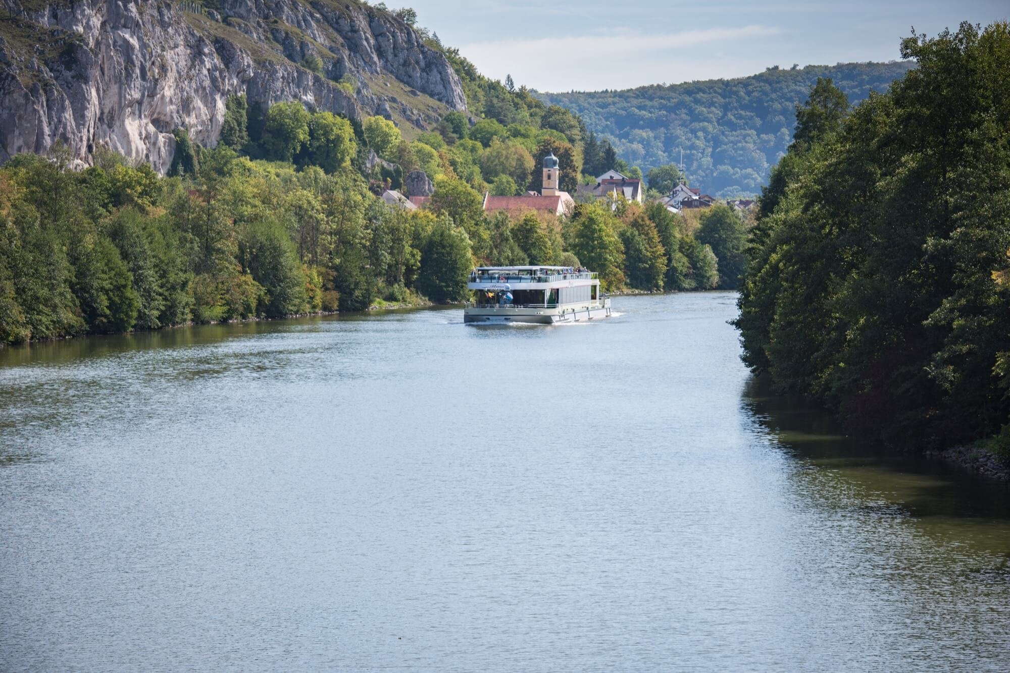 Steile Felsen und Wälder ragen am Ufer zu beiden Seiten der MS Renate auf